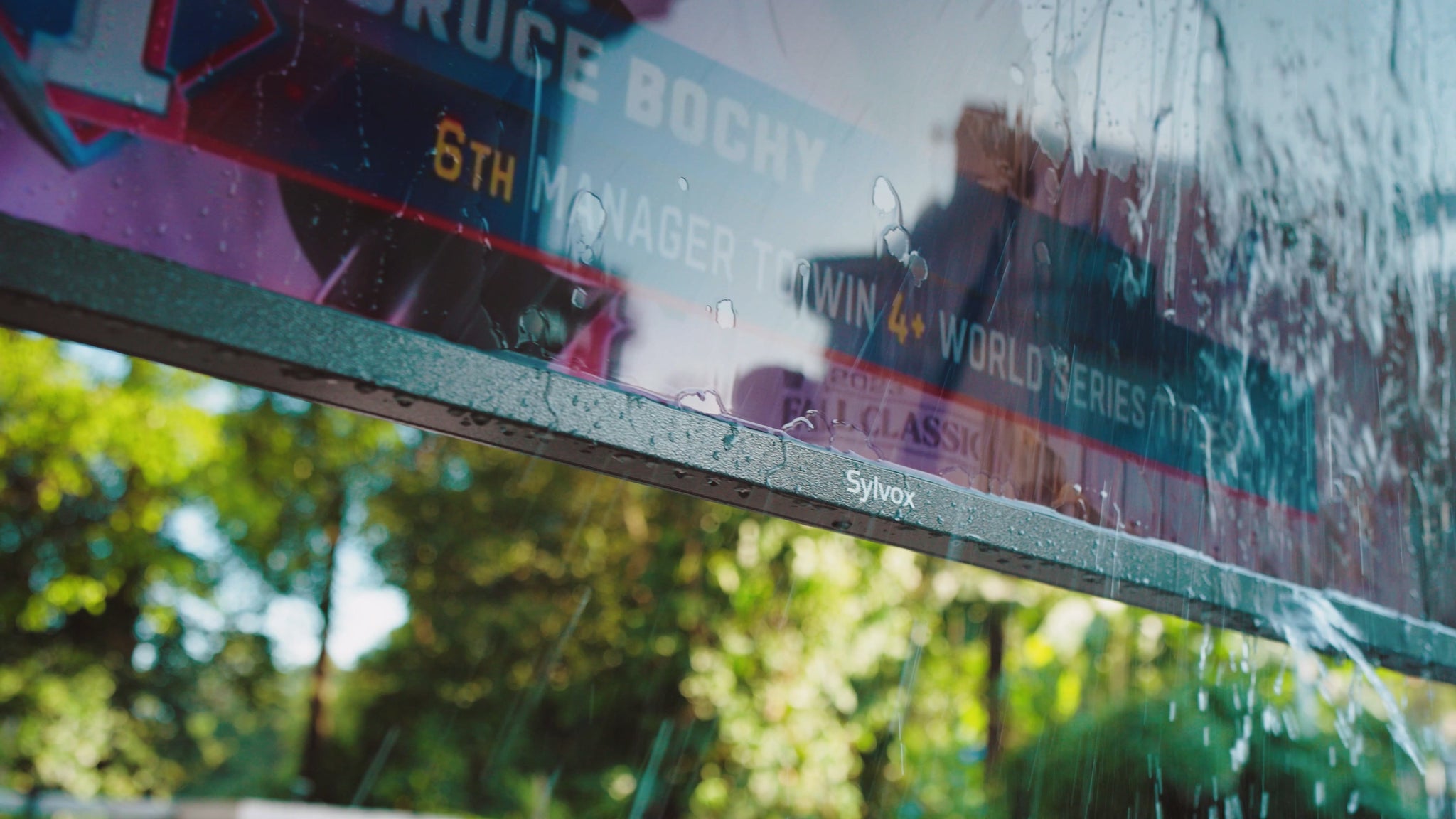 An outdoor TV is drenched with water and playing content normally.